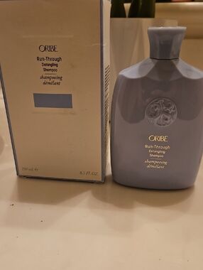 Oribe Run-Through Detangling Shampoo in Lavender Bottle with Gold Lettering